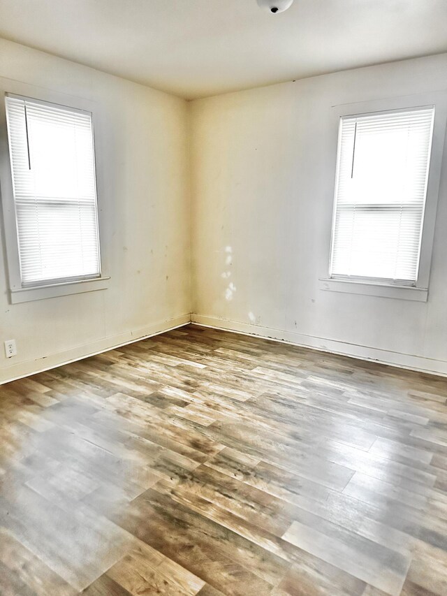 spare room featuring hardwood / wood-style flooring and plenty of natural light