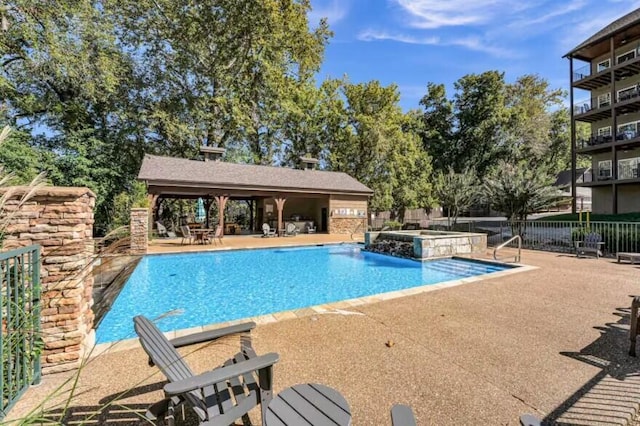 view of pool featuring a gazebo, pool water feature, a patio, and a hot tub