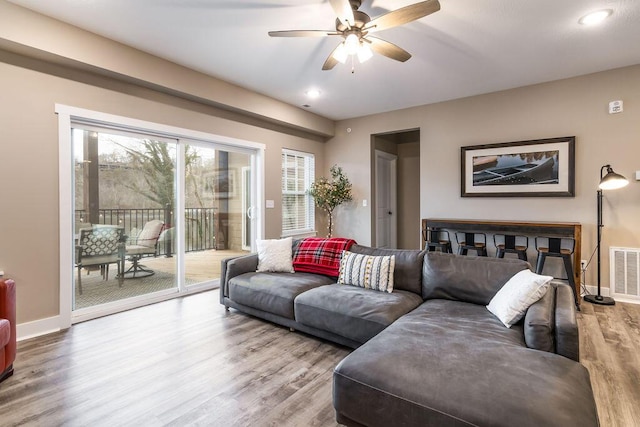 living room featuring wood-type flooring and ceiling fan