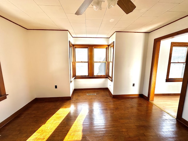 unfurnished room with ceiling fan, dark hardwood / wood-style floors, and ornamental molding