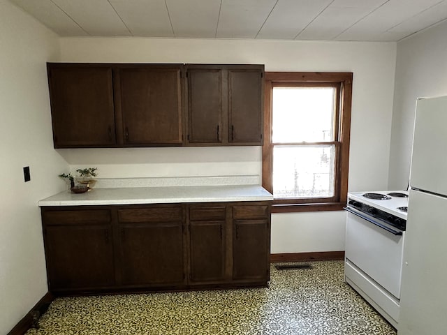 kitchen with dark brown cabinets and white appliances