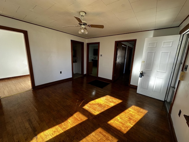 empty room featuring dark hardwood / wood-style flooring, ceiling fan, and crown molding