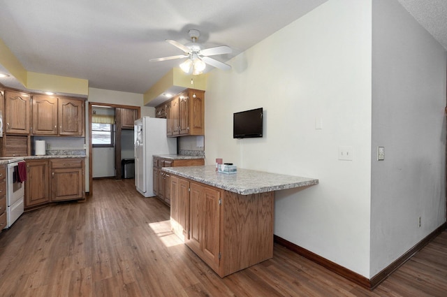 kitchen featuring ceiling fan, a center island, white fridge, and dark wood-type flooring