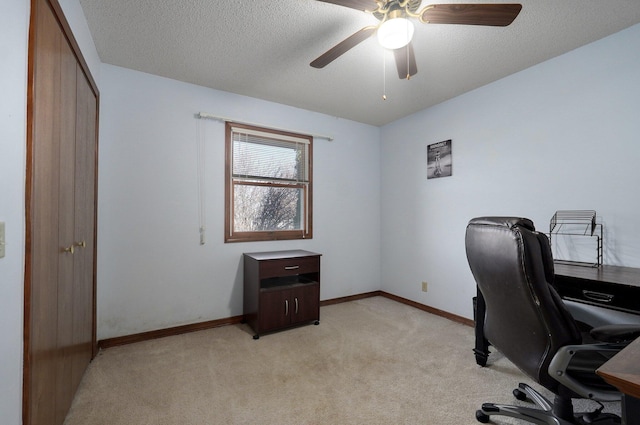 office featuring a textured ceiling, light colored carpet, and ceiling fan