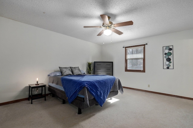 carpeted bedroom with ceiling fan and a textured ceiling