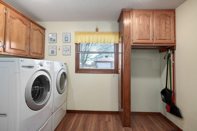 clothes washing area featuring cabinets, independent washer and dryer, a textured ceiling, and wood-type flooring