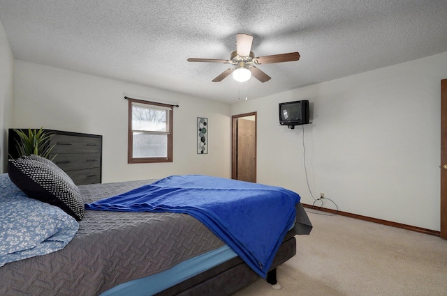 bedroom featuring a textured ceiling, ceiling fan, and light carpet