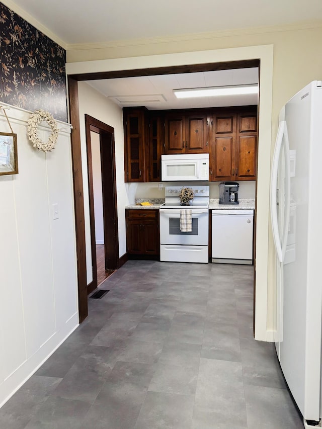 kitchen featuring dark brown cabinetry and white appliances