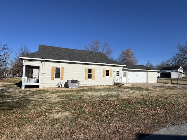 view of front of home featuring a garage, central air condition unit, and a front lawn