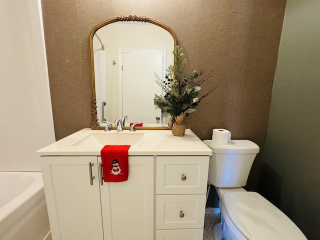 bathroom with vanity, toilet, and a tub to relax in