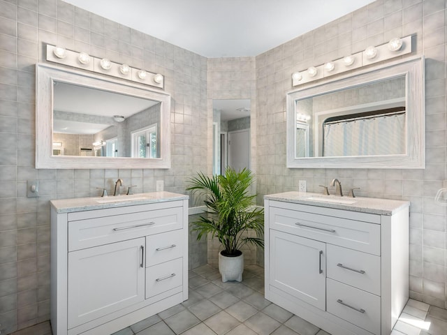 bathroom with vanity, tile patterned floors, and tile walls