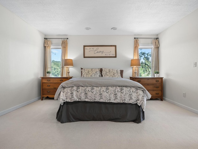 bedroom featuring light carpet and a textured ceiling