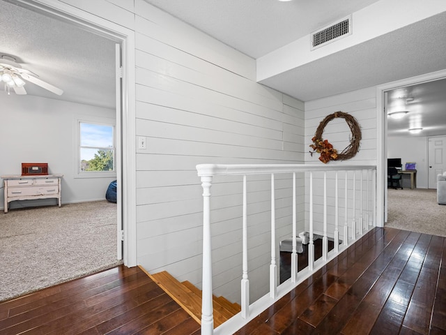 hall with carpet and a textured ceiling