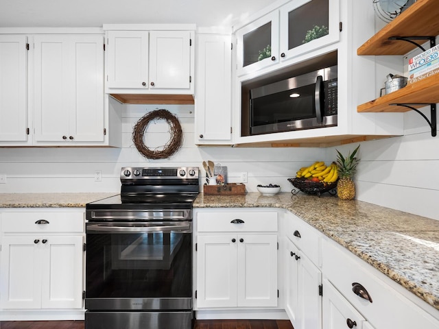 kitchen with light stone countertops, white cabinetry, and stainless steel appliances