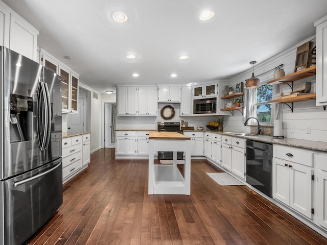 kitchen featuring sink, hanging light fixtures, light stone counters, white cabinetry, and stainless steel appliances