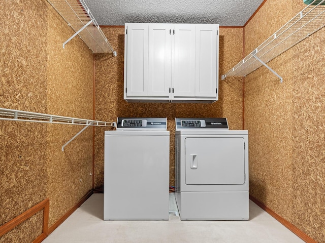 washroom with cabinets and washing machine and clothes dryer