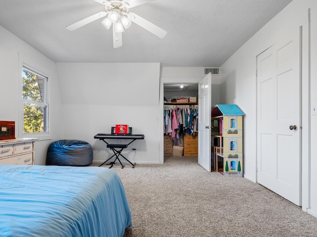 carpeted bedroom with ceiling fan, a textured ceiling, and a closet