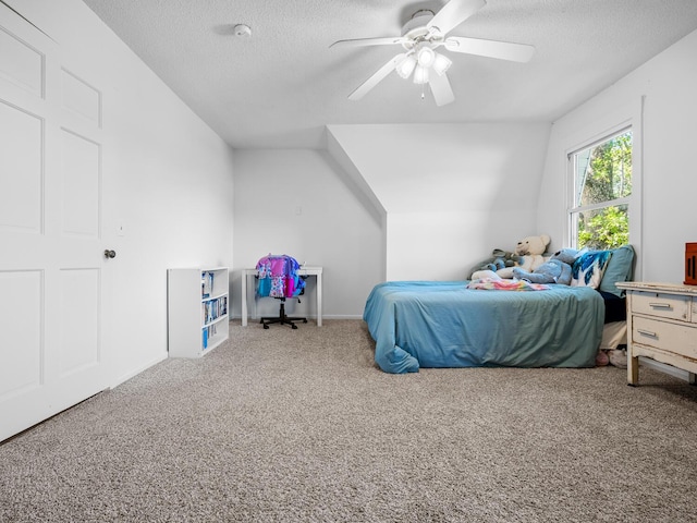 bedroom featuring ceiling fan, carpet floors, a textured ceiling, and lofted ceiling