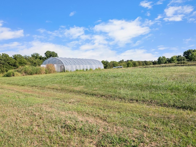 view of yard with a rural view and an outdoor structure