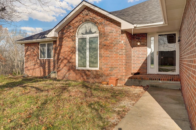 view of exterior entry featuring a yard