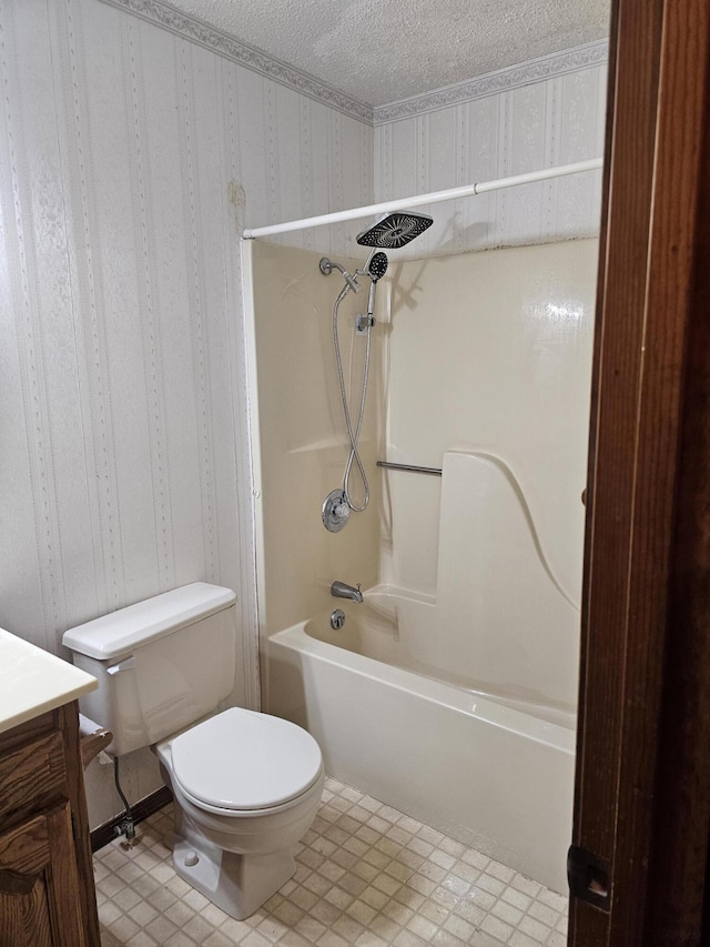 full bathroom featuring toilet, vanity, a textured ceiling, and washtub / shower combination