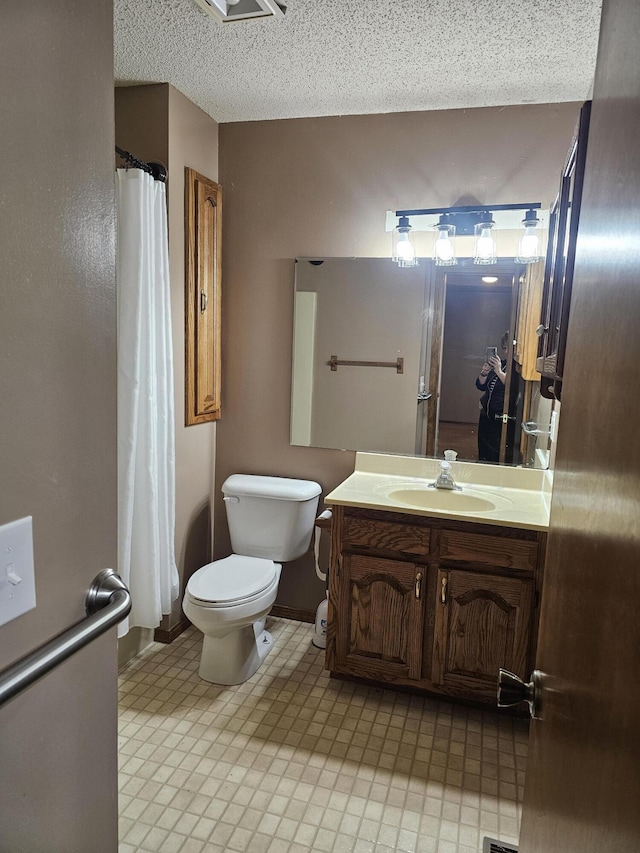 bathroom featuring vanity, a textured ceiling, and toilet