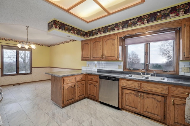 kitchen with dishwasher, sink, hanging light fixtures, a notable chandelier, and kitchen peninsula