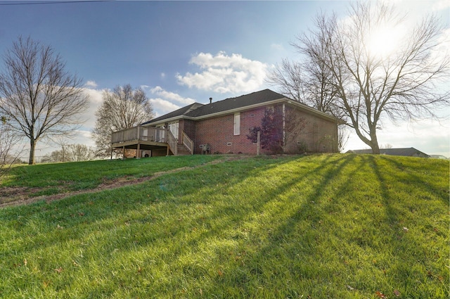 view of side of property featuring a wooden deck and a lawn