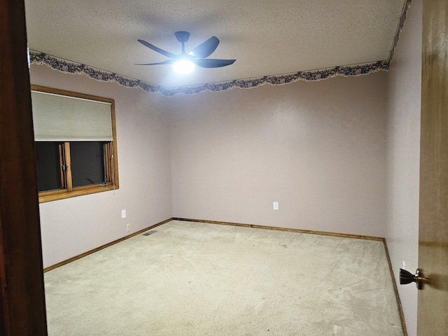 carpeted spare room featuring a textured ceiling and ceiling fan