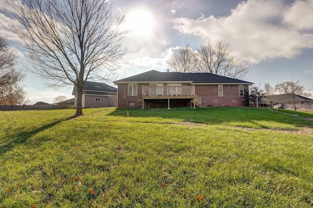 rear view of property featuring a yard and a deck