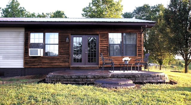 doorway to property featuring a lawn, a patio area, and french doors