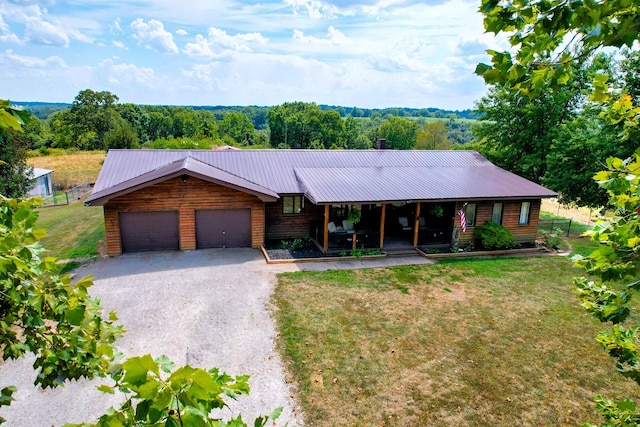 view of front of property with a porch, a garage, and a front lawn