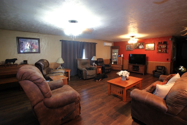 living room featuring ceiling fan, a textured ceiling, a wall unit AC, and dark wood-type flooring