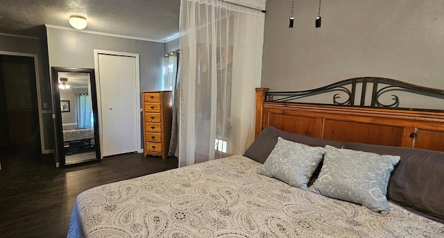 bedroom featuring a closet, dark hardwood / wood-style flooring, a textured ceiling, and ornamental molding