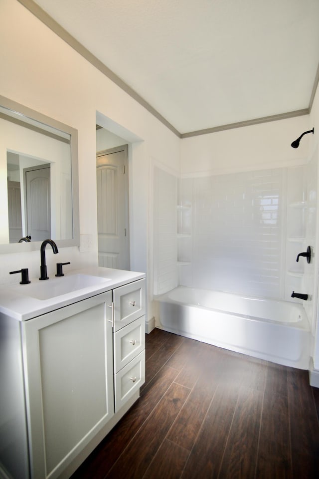 bathroom with bathtub / shower combination, vanity, hardwood / wood-style flooring, and ornamental molding