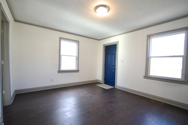 empty room featuring ornamental molding and dark wood-type flooring