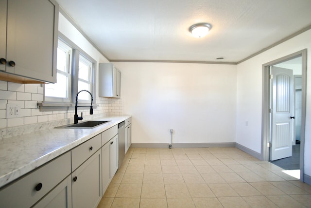 kitchen featuring tasteful backsplash, ornamental molding, gray cabinetry, sink, and light tile patterned floors