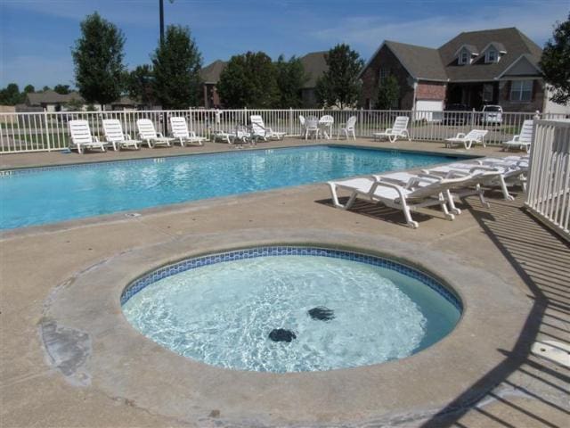 view of swimming pool with a hot tub and a patio area