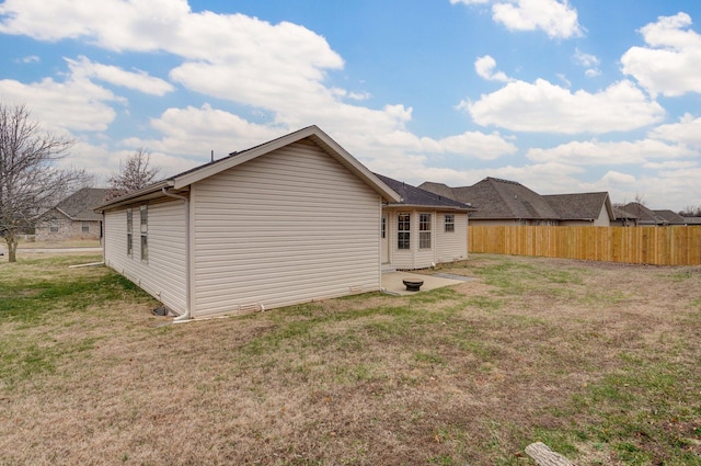 rear view of house featuring a patio area and a yard