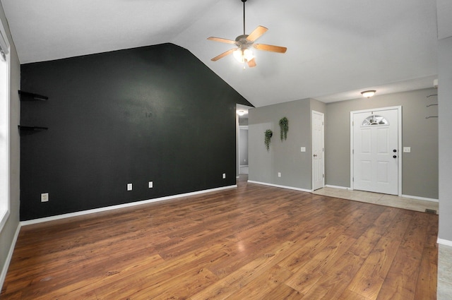 unfurnished living room with ceiling fan, hardwood / wood-style floors, and lofted ceiling