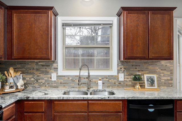 kitchen with backsplash, light stone counters, sink, and black dishwasher