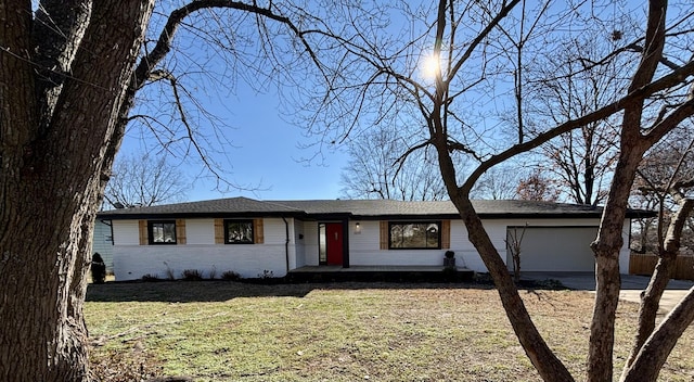 ranch-style house featuring a front yard and a garage