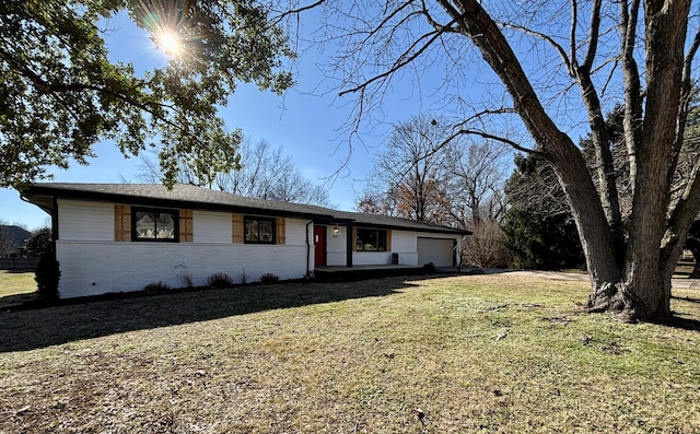 ranch-style house featuring a front lawn and a garage