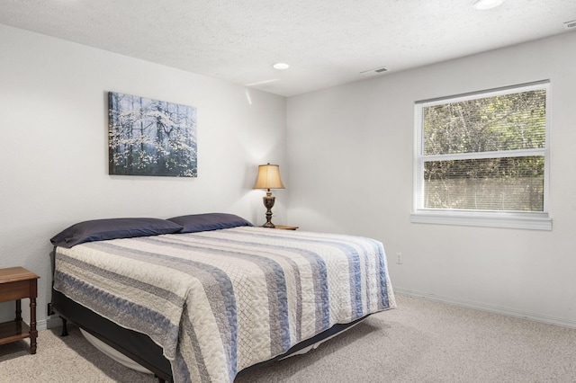 carpeted bedroom featuring a textured ceiling