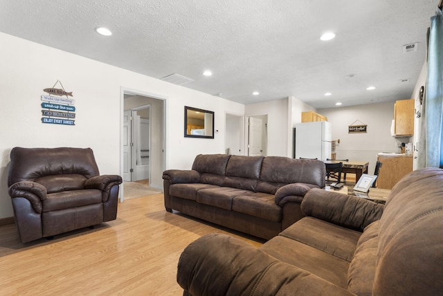 living room featuring a textured ceiling and light wood-type flooring