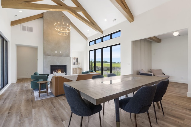 dining area featuring hardwood / wood-style flooring, a fireplace, beamed ceiling, and high vaulted ceiling