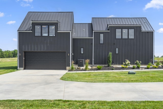 modern farmhouse featuring cooling unit, a front yard, and a garage