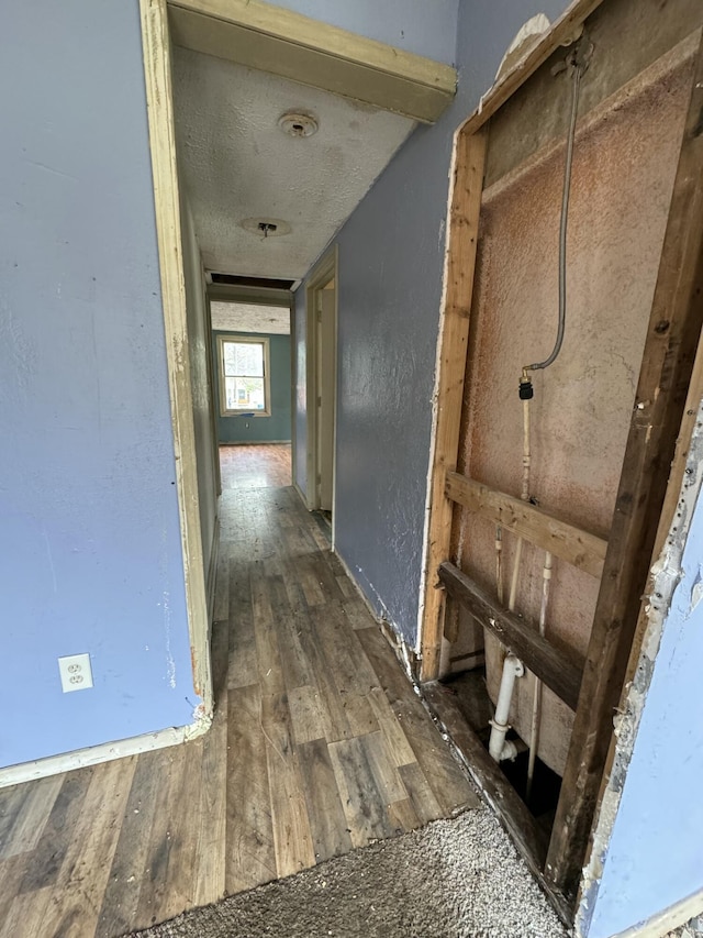 hall with dark wood-type flooring and a textured ceiling