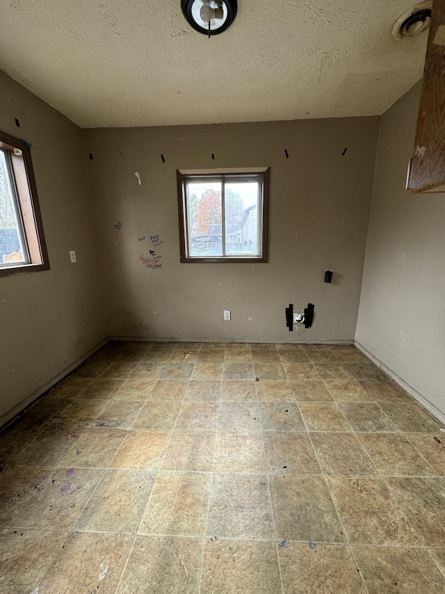 unfurnished room with a textured ceiling