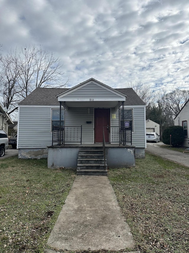 bungalow-style home with covered porch and a front lawn